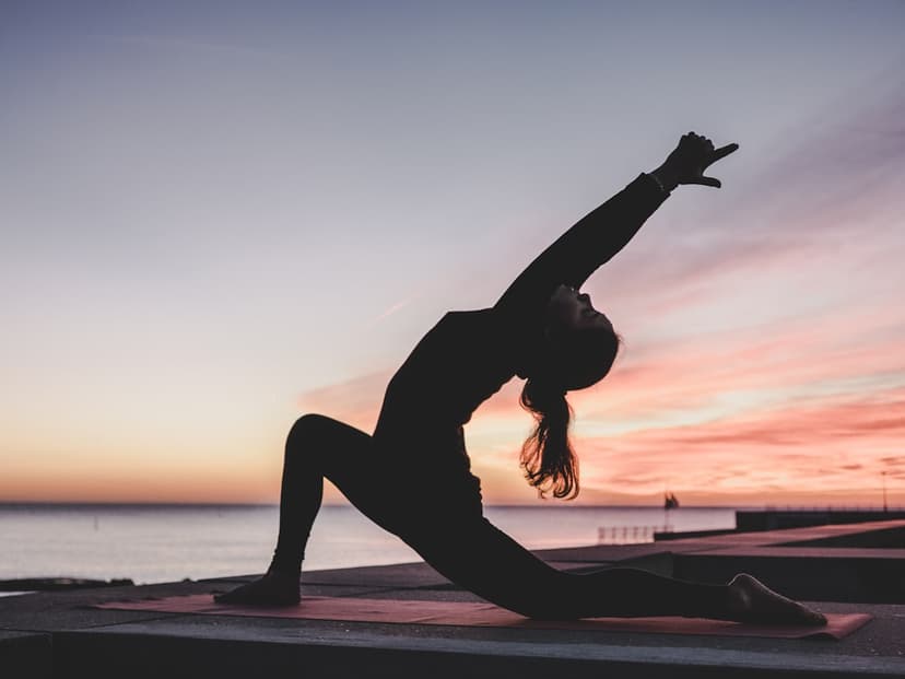 Yoga practitioner in a graceful pose at sunset